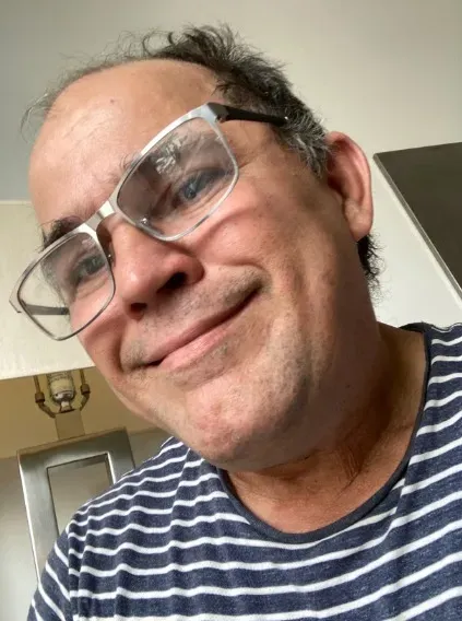Homem sorridente usando óculos, representando cliente satisfeito com os resultados do Durasil Sérum Íntimo.